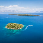 Tropical island washed by blue sea water on sunny day