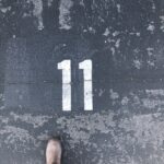 Person standing on concrete floor with number 11 paint