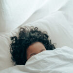Unrecognizable person sleeping under blanket