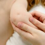 person holding a baby s arm
